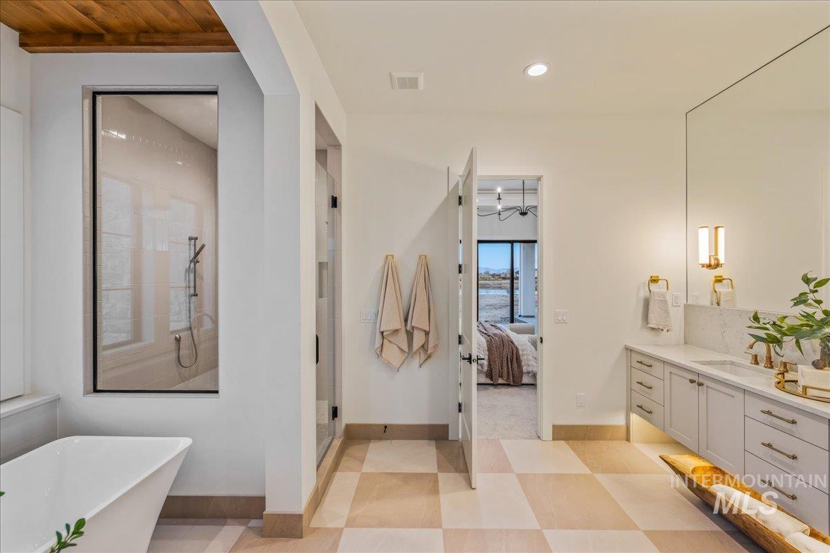 Bathroom with a freestanding bath, vanity, connected bathroom, a shower stall, and recessed lighting