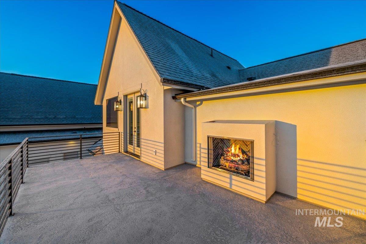 View of patio featuring a lit fireplace
