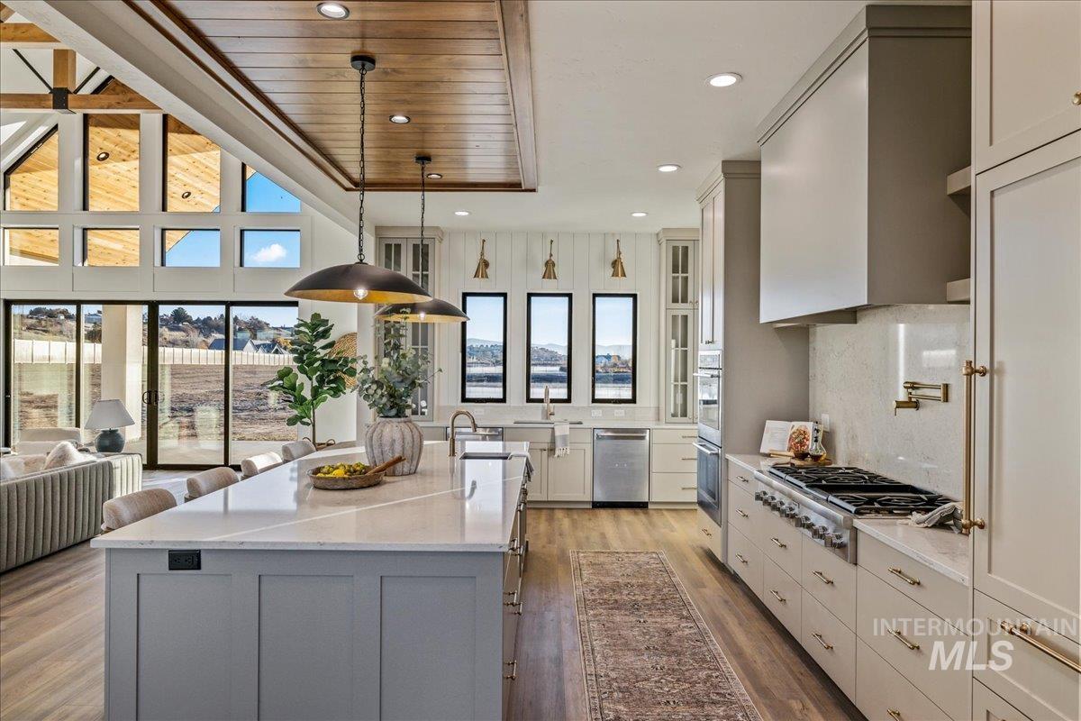 Kitchen with light stone countertops, decorative light fixtures, dark wood-style flooring, recessed lighting, and wood ceiling