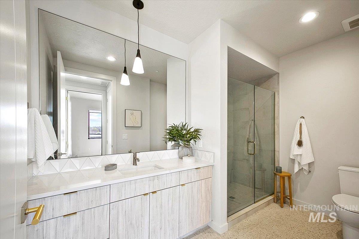 Bathroom with a stall shower, vanity, recessed lighting, and a textured ceiling