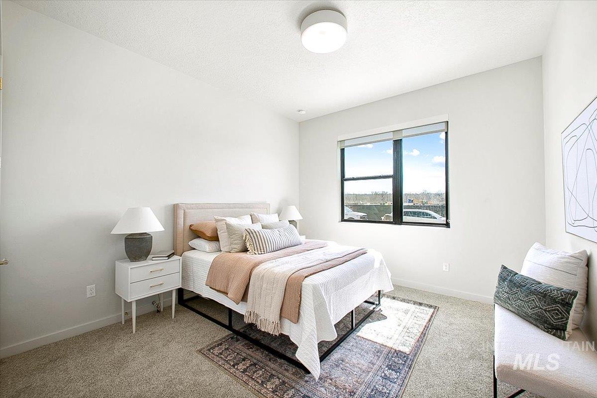 Bedroom featuring light colored carpet and a textured ceiling