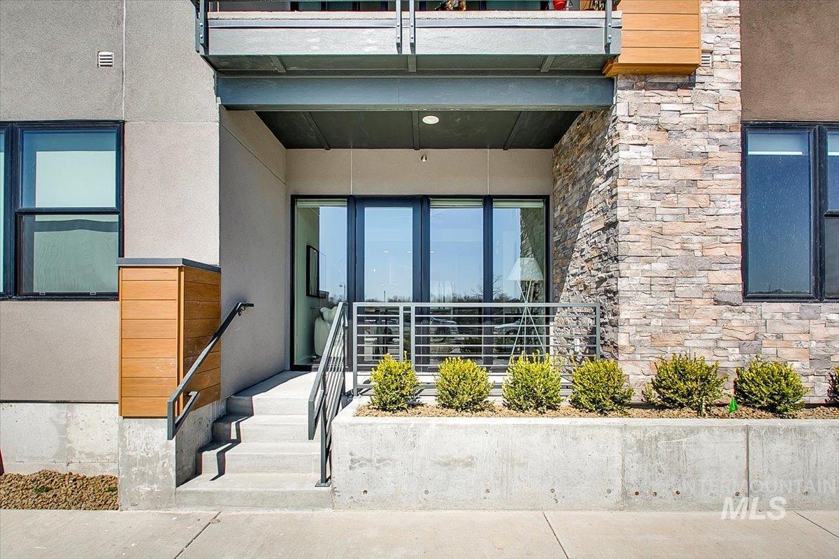 Doorway to property featuring stone siding and stucco siding
