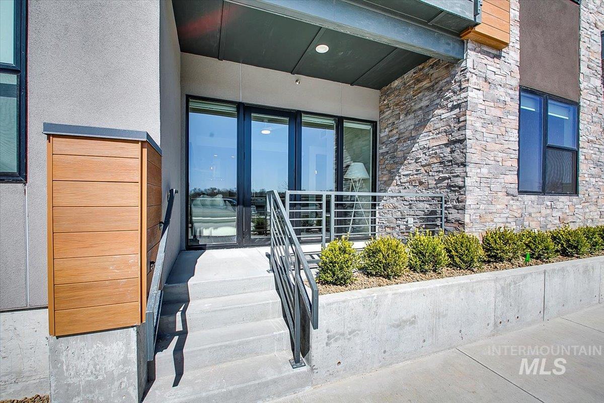 Doorway to property featuring stone siding and stucco siding