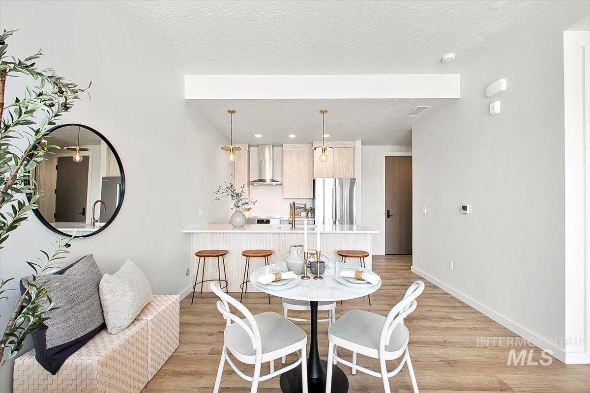Dining room featuring light wood-type flooring and a textured ceiling
