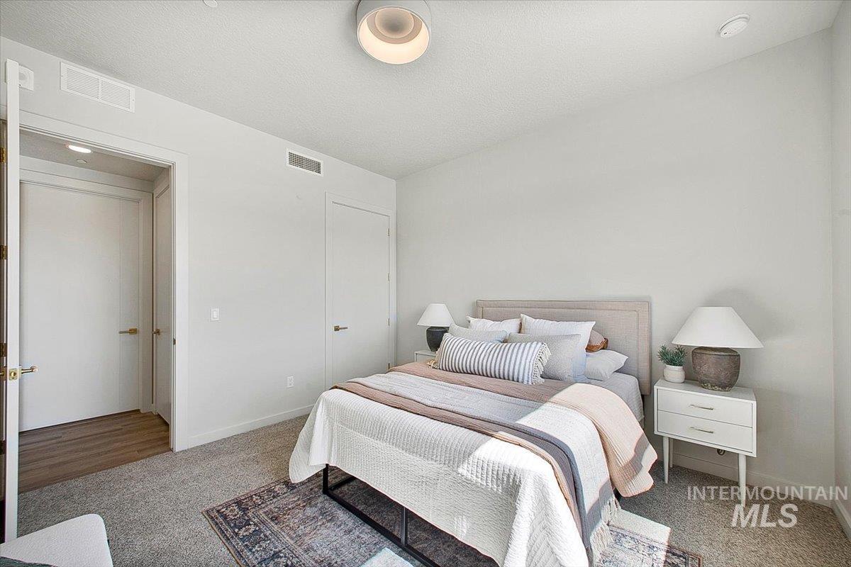 Bedroom with light carpet and a textured ceiling