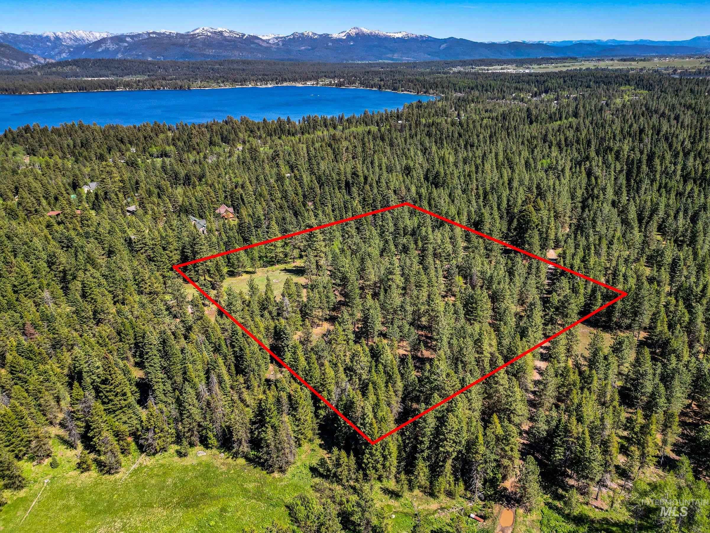 Aerial view of property's location with a mountain backdrop and property parcel outlined
