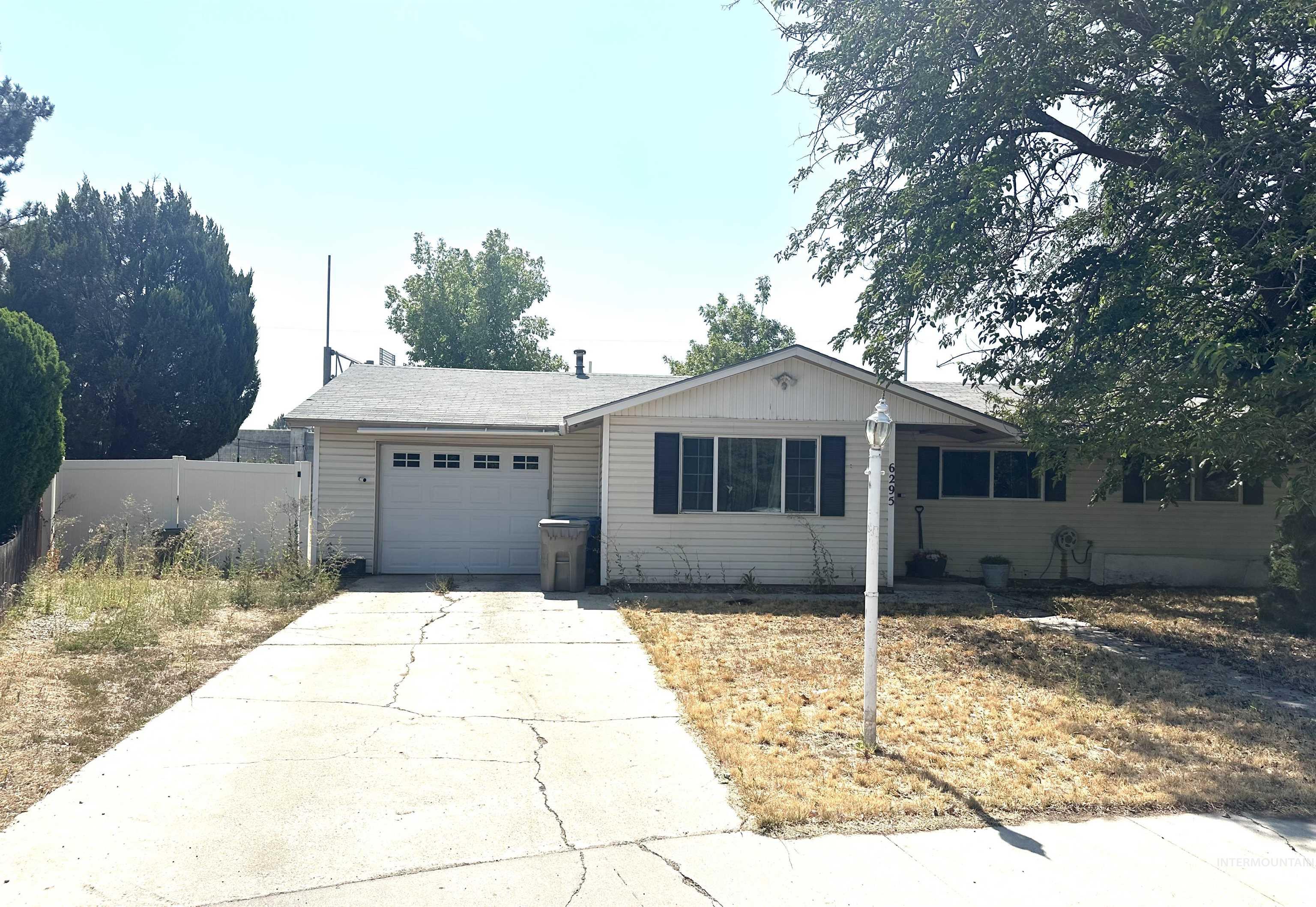 Ranch-style home featuring a garage and concrete driveway