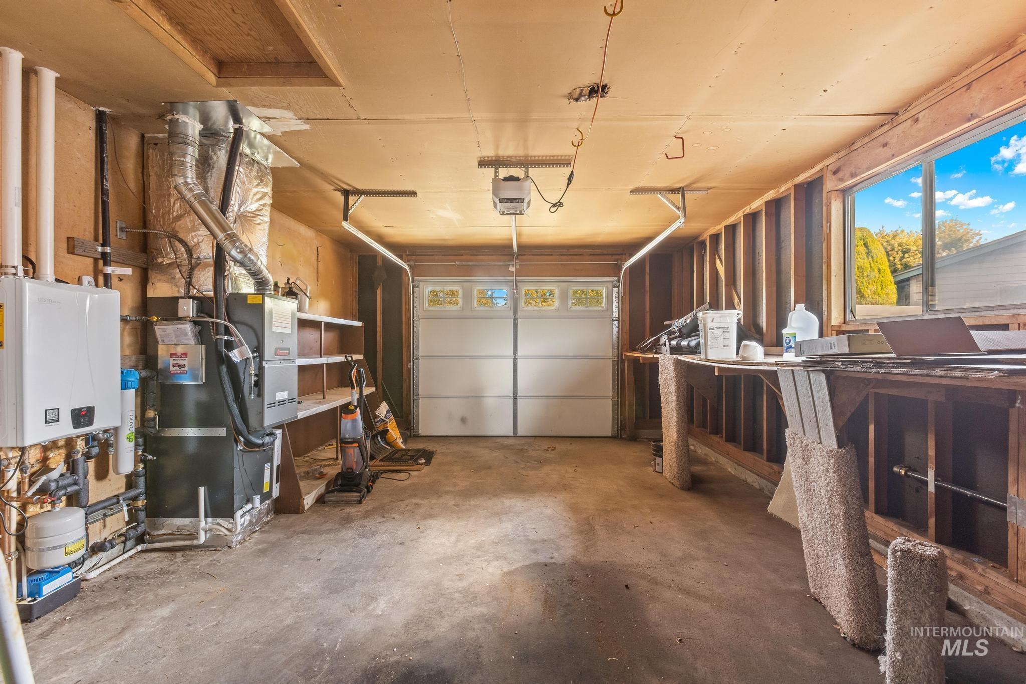 Garage with water heater, a garage door opener, and heating unit