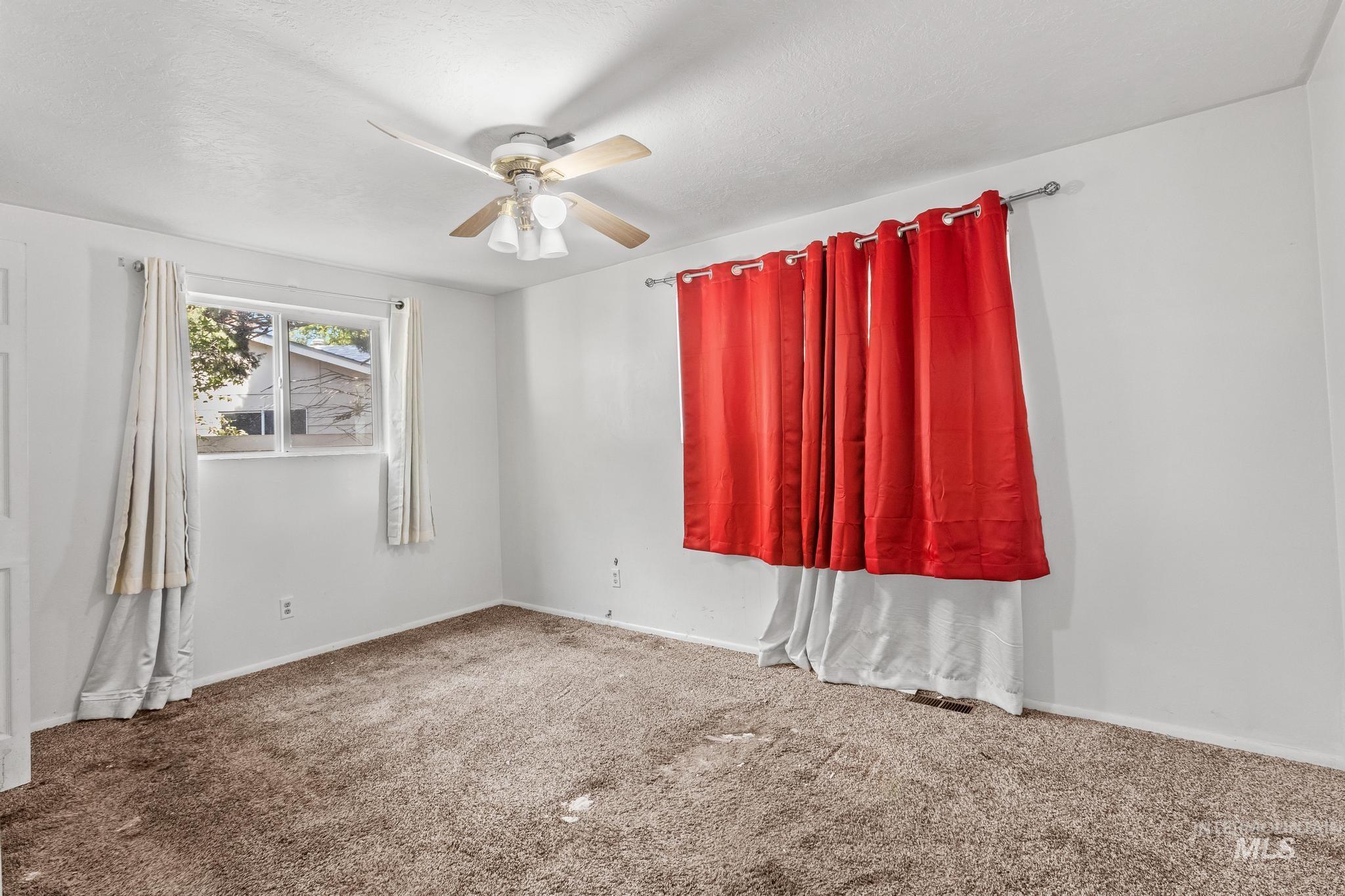 Spare room featuring ceiling fan and carpet floors