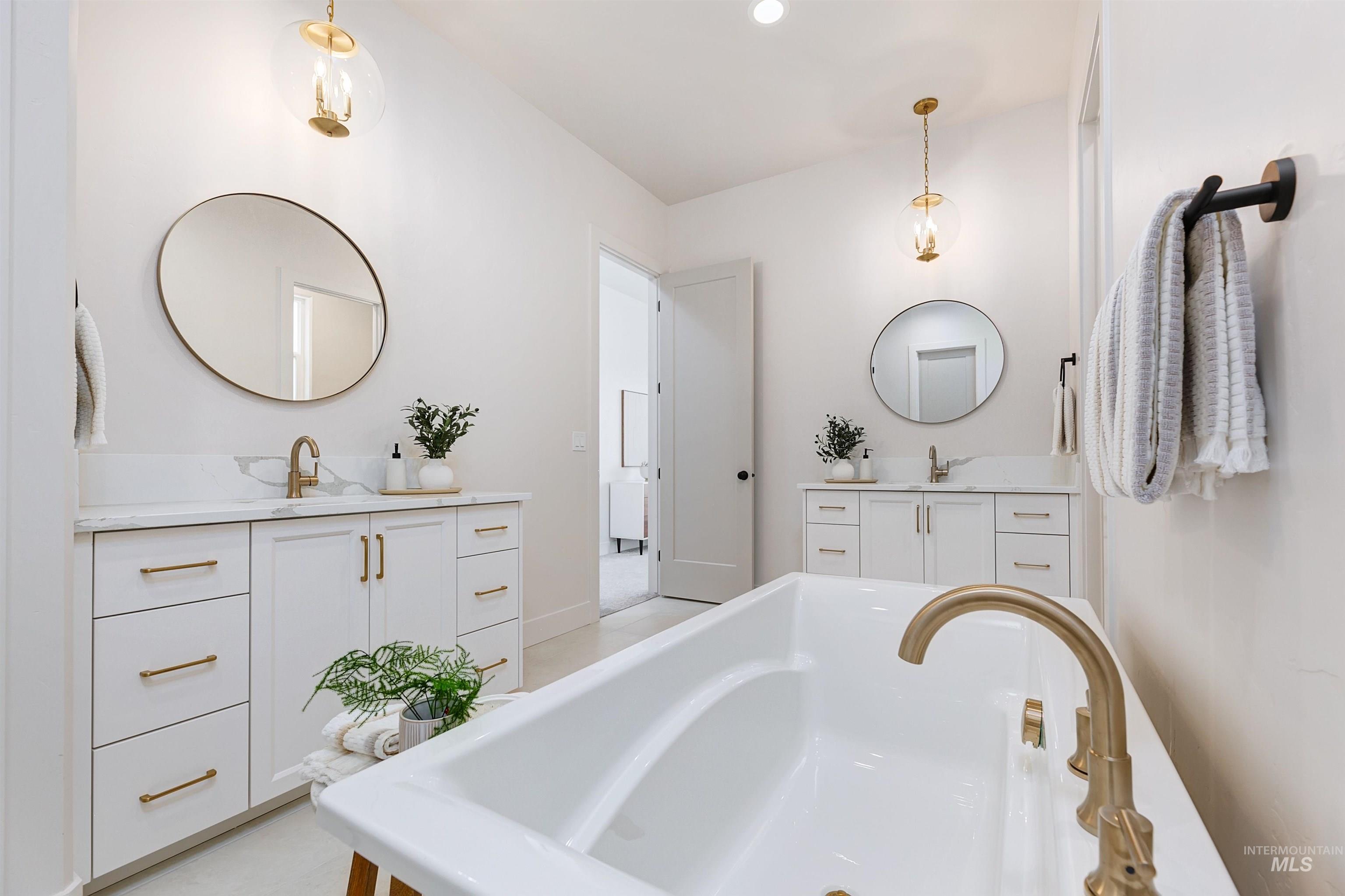 Bathroom with two vanities, a bathtub, and recessed lighting