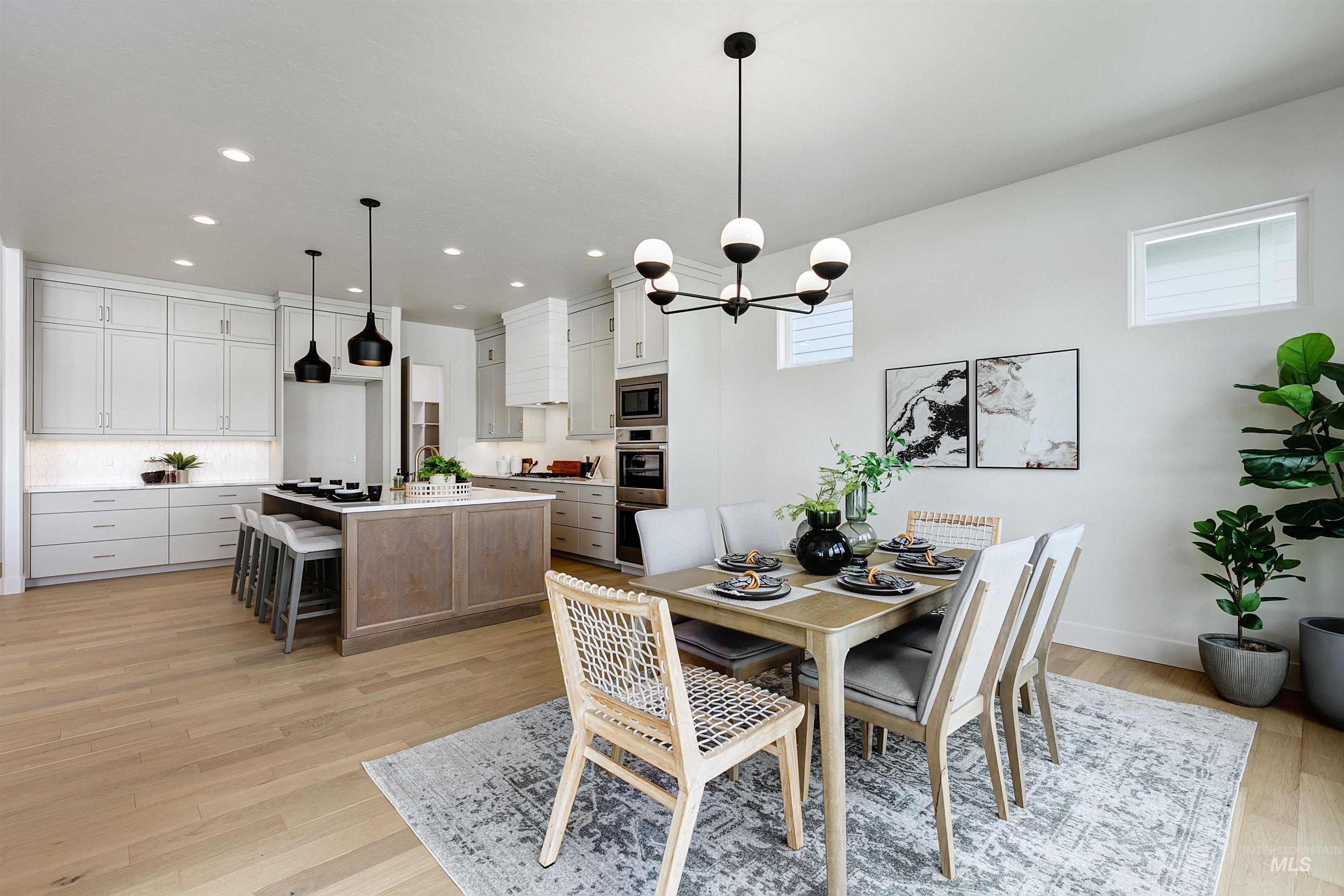 Dining space with light wood-style floors, recessed lighting, and a chandelier