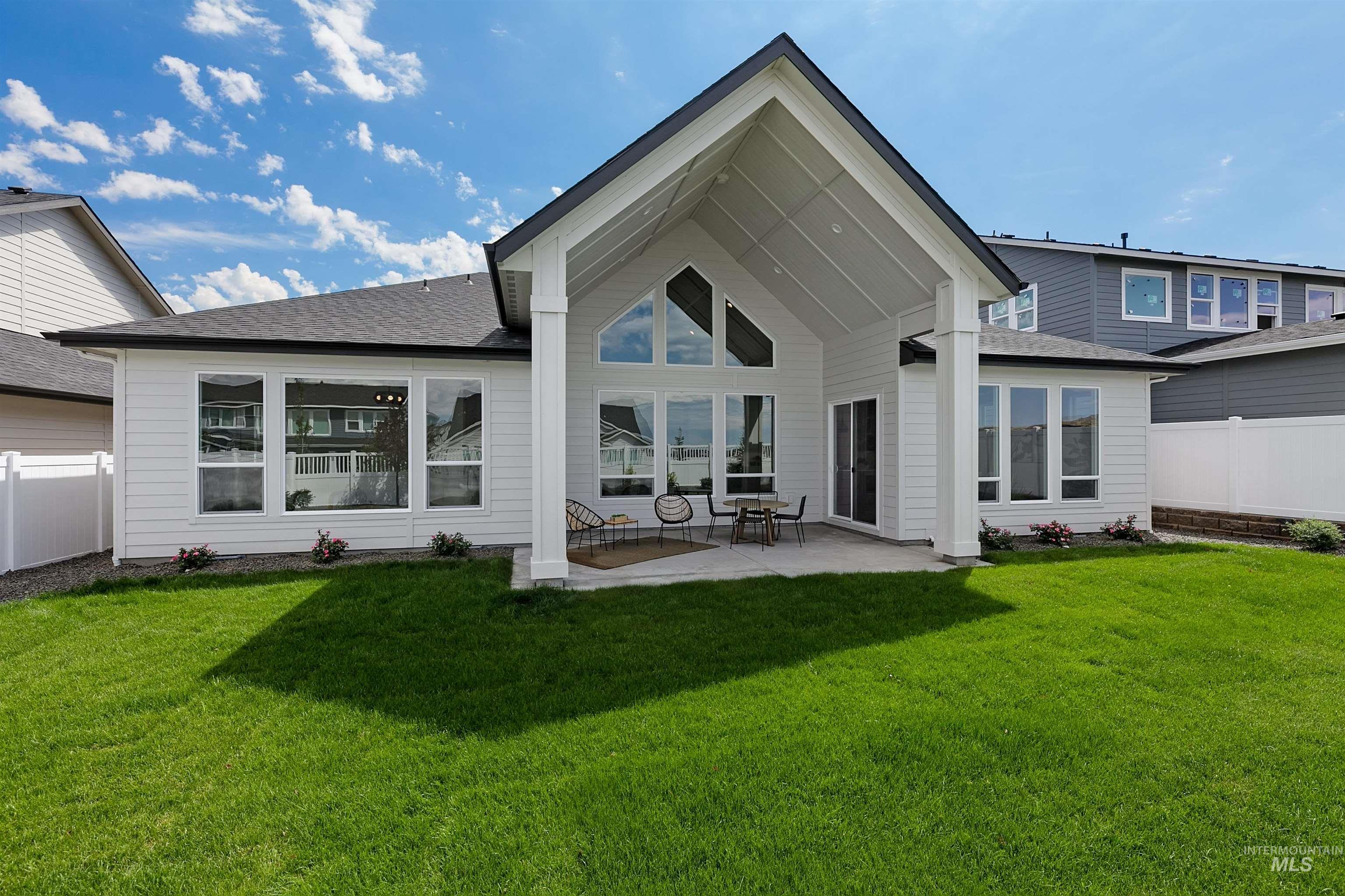 Rear view of house featuring a patio area and a shingled roof