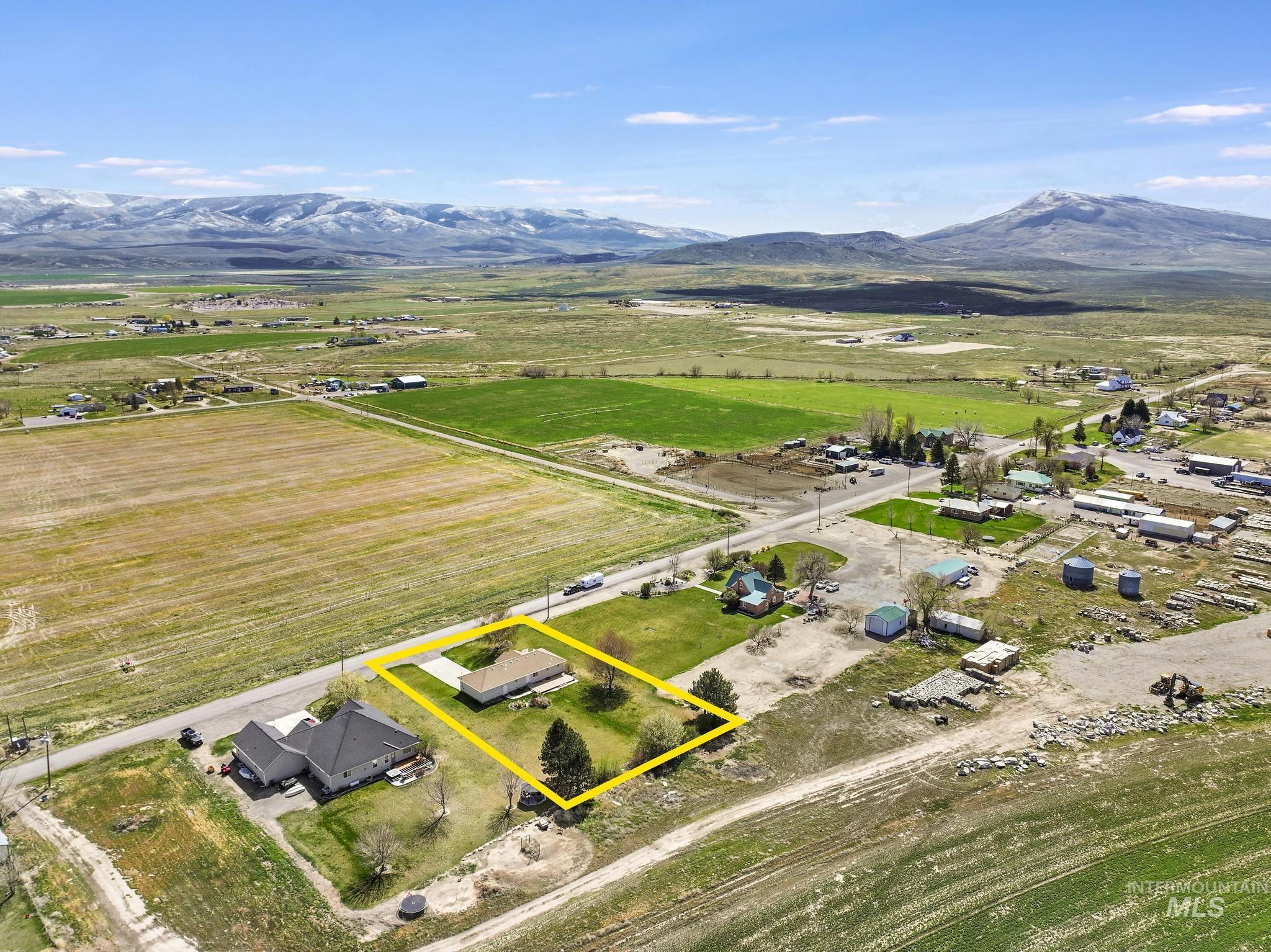 Aerial view of sparsely populated area featuring property parcel outlined and a mountain backdrop