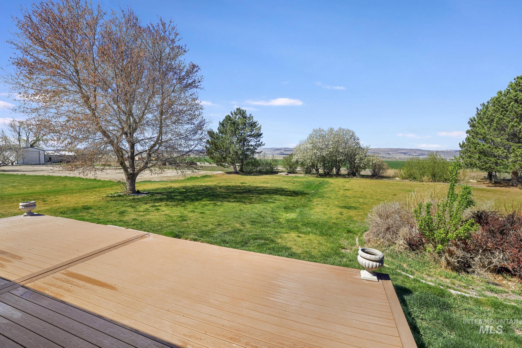 Wooden terrace featuring a yard and a rural view