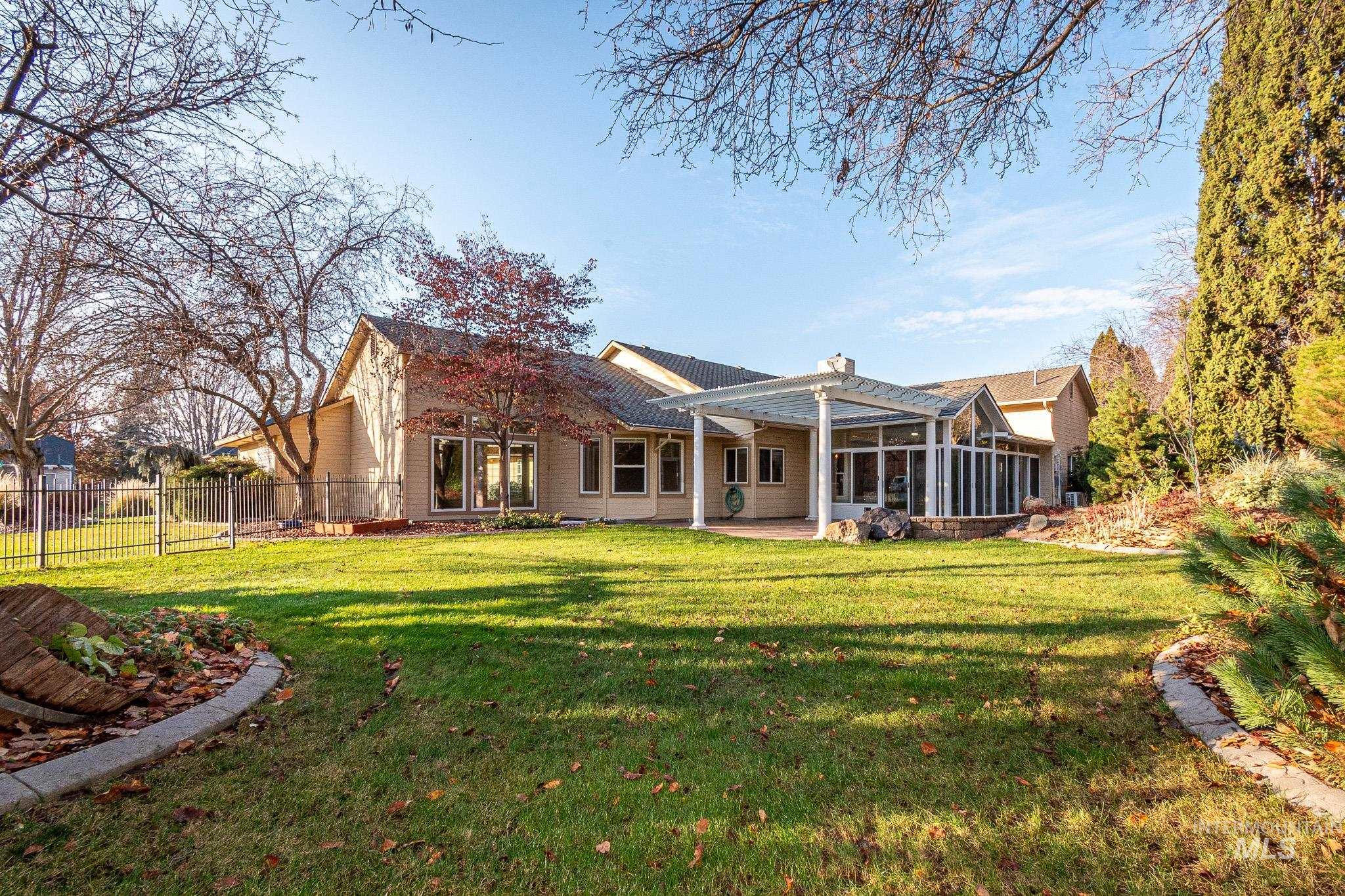 Rear view of house with a patio, a sunroom, a chimney, and a pergola