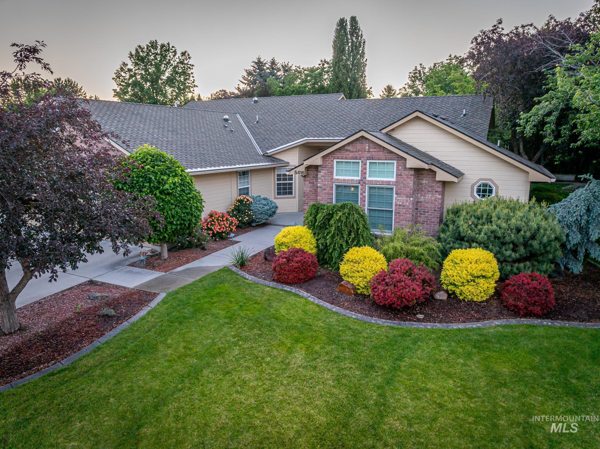 Ranch-style home with a front yard, a shingled roof, and brick siding