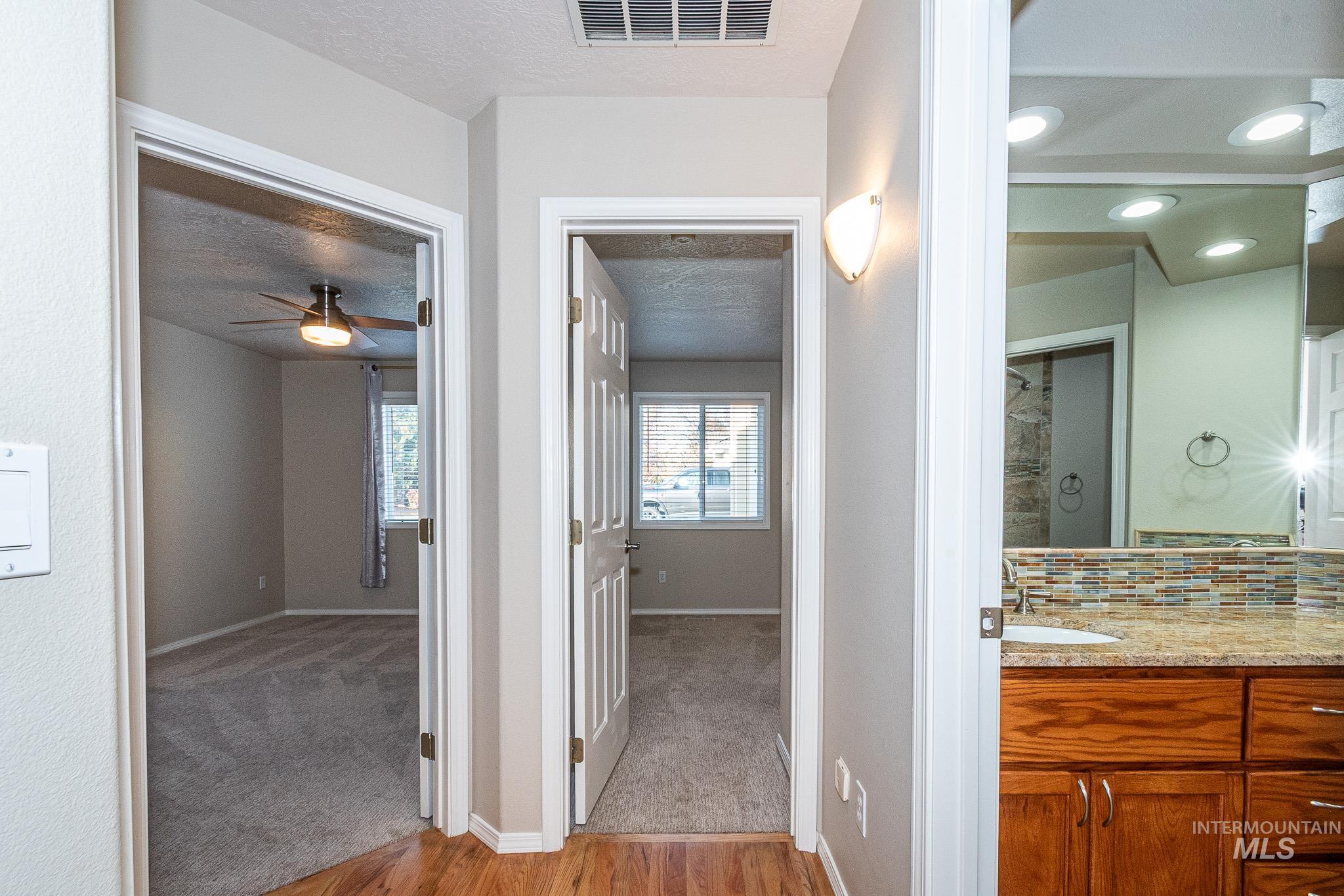 Corridor with light wood-type flooring and a textured ceiling