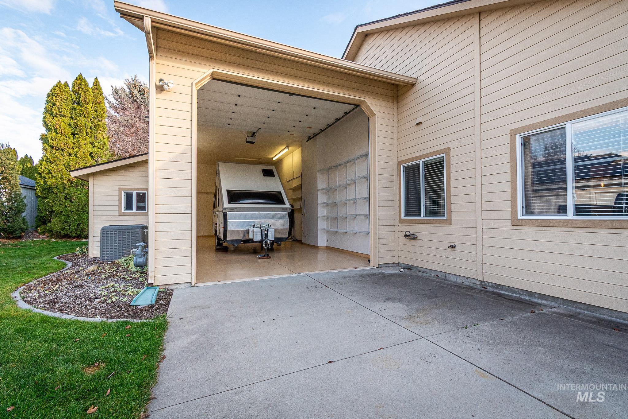 View of side of home featuring a patio, a garage, and driveway