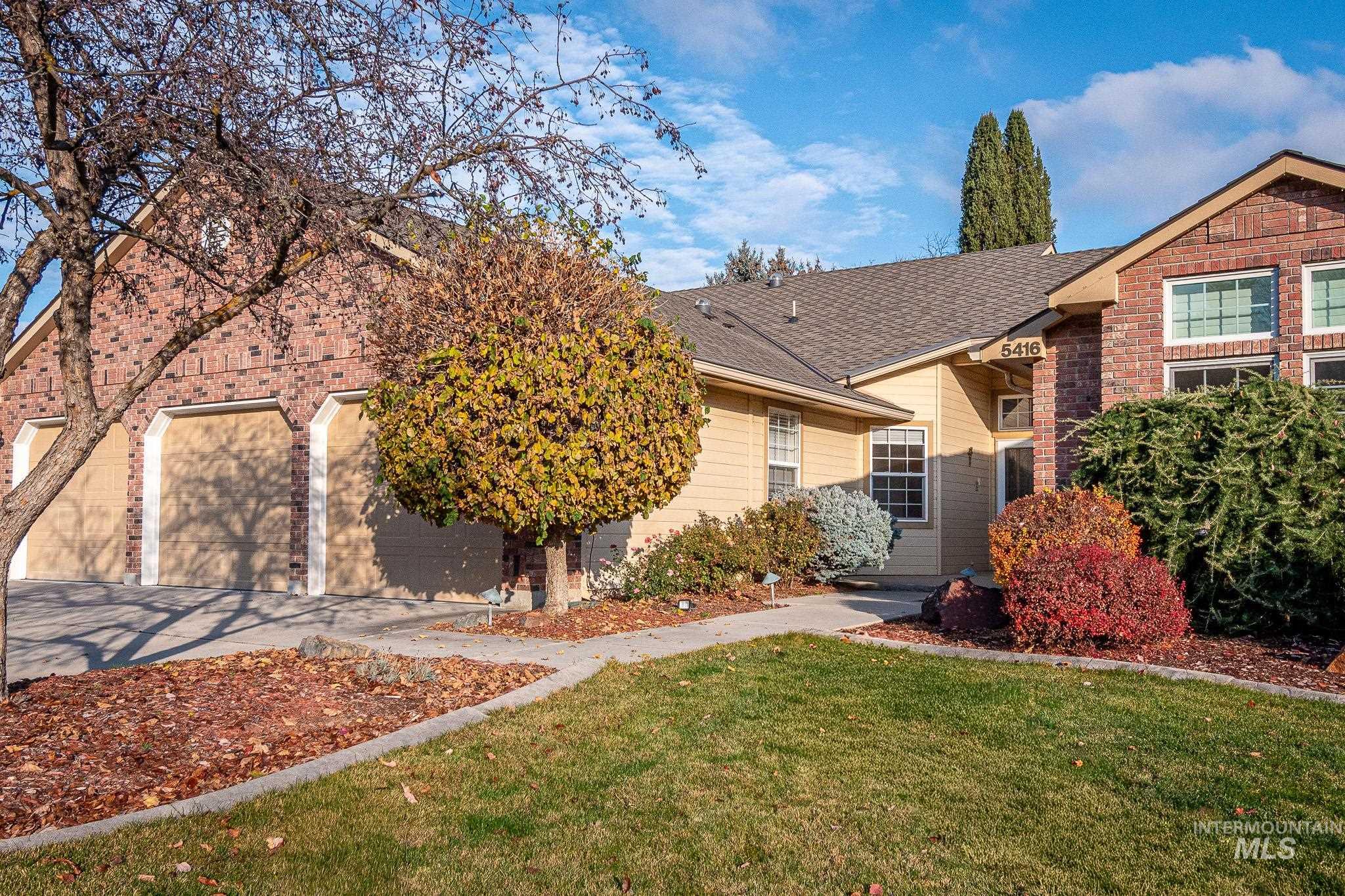 Ranch-style home with a shingled roof, a front lawn, brick siding, and concrete driveway