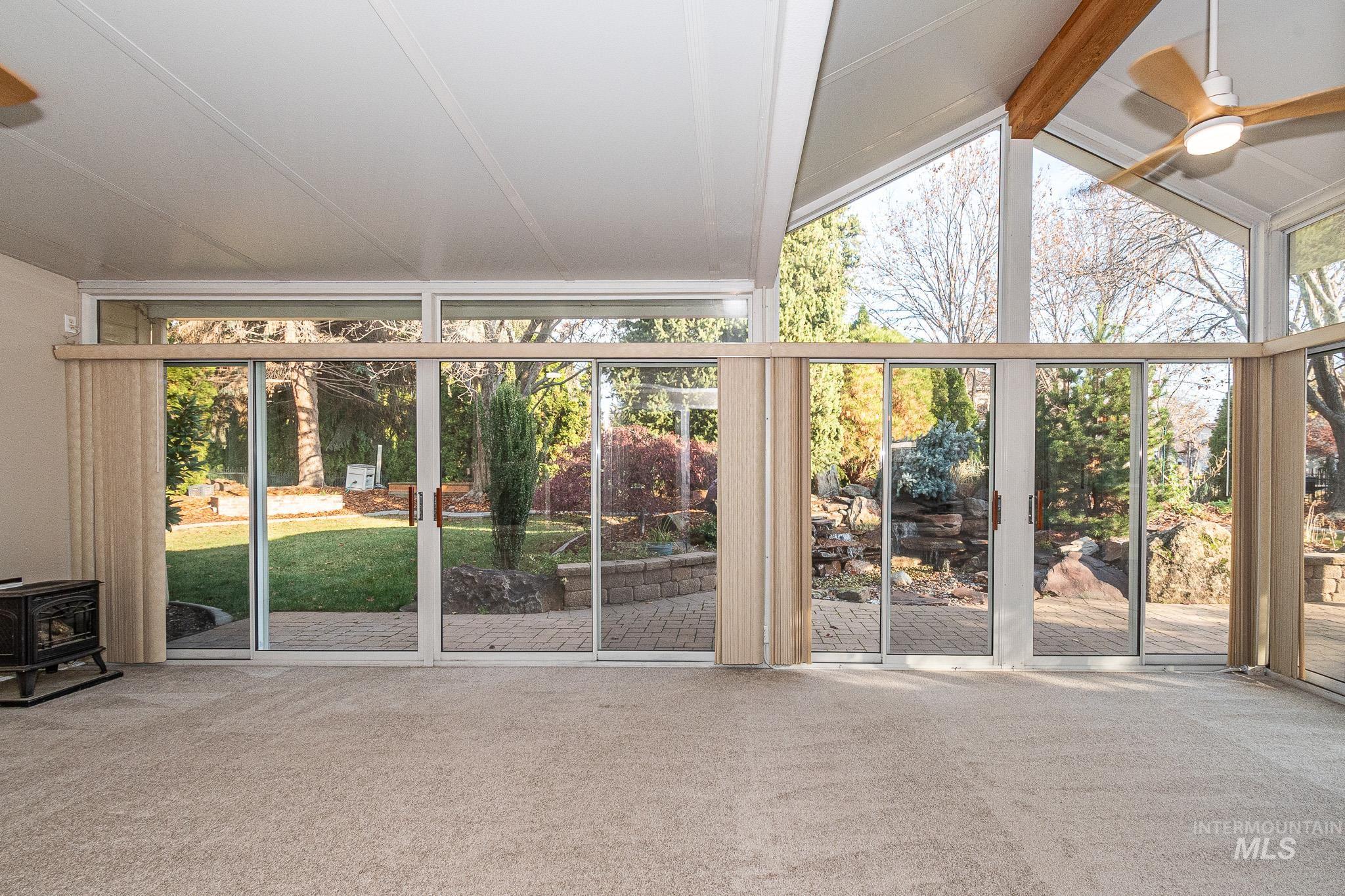 Unfurnished sunroom featuring a wood stove and plenty of natural light