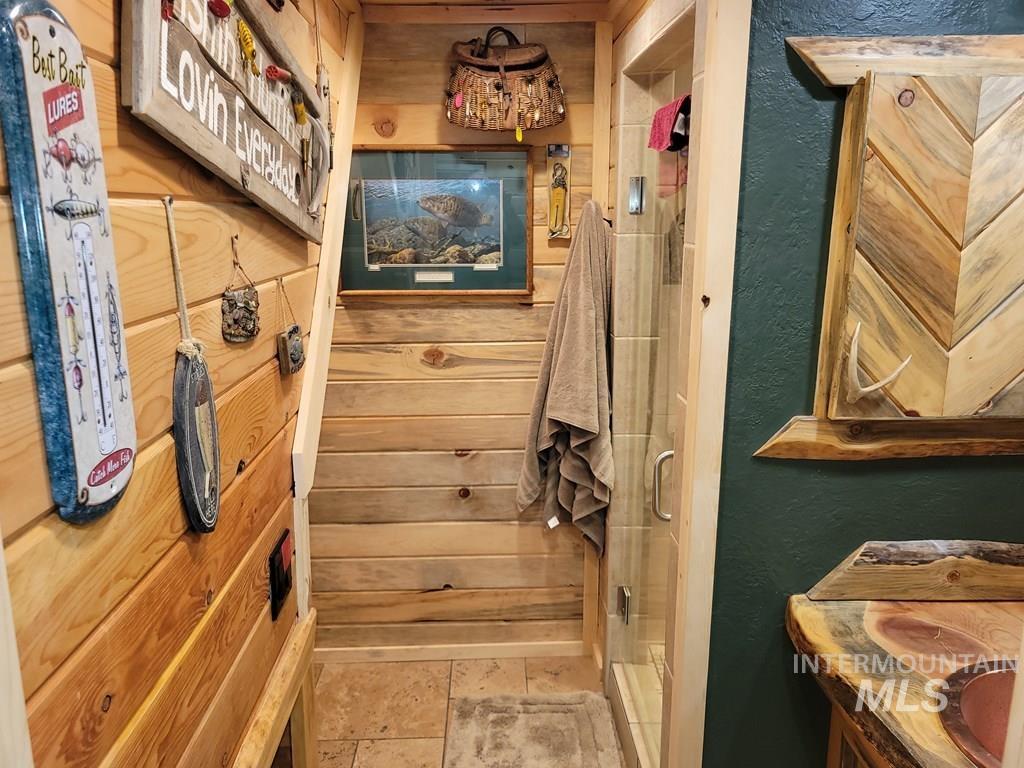 Bathroom featuring a textured wall and a shower stall