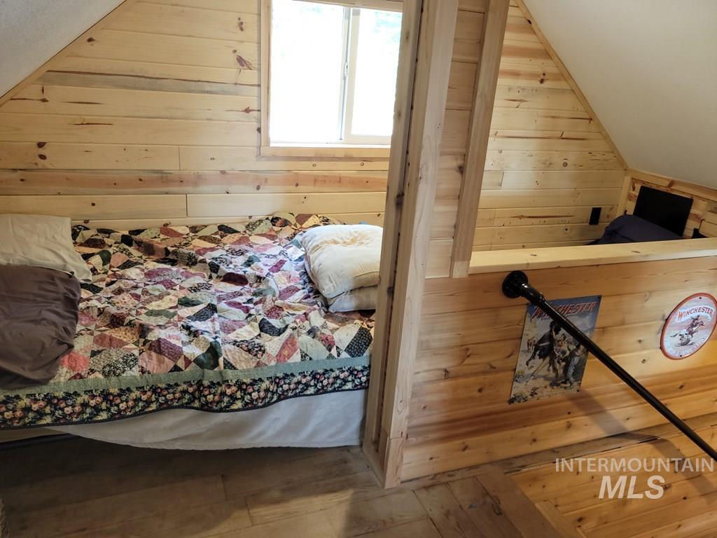 Bedroom featuring wooden walls and wood finished floors