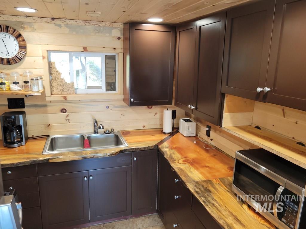 Kitchen featuring stainless steel microwave and dark brown cabinetry