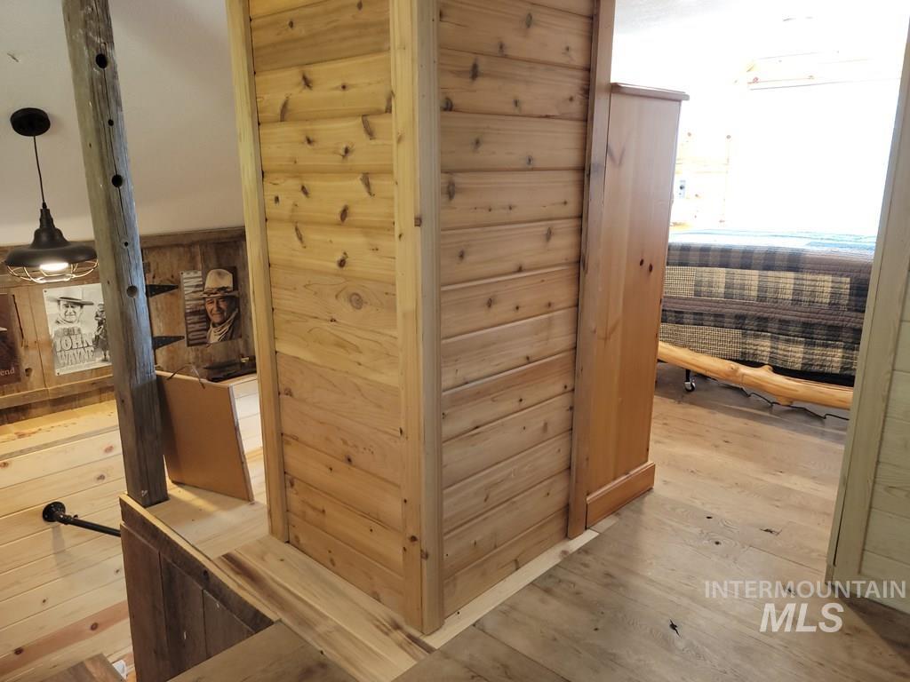 Corridor featuring wood walls and light wood-style flooring