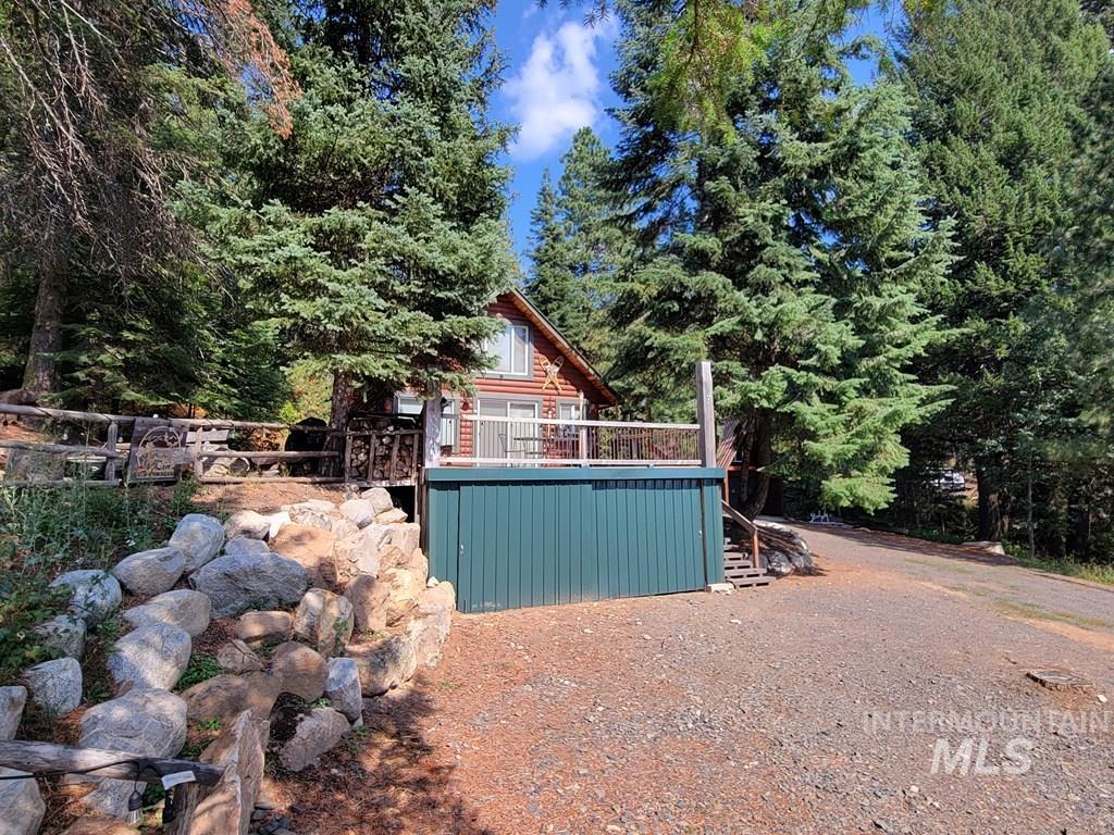 View of yard featuring a wooden deck, a wooded view, and stairs