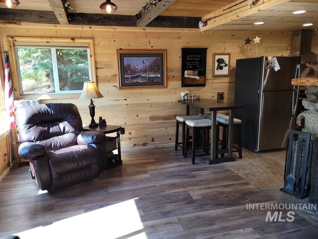 Living area featuring wooden walls, wood finished floors, and a wood ceiling with exposed beams