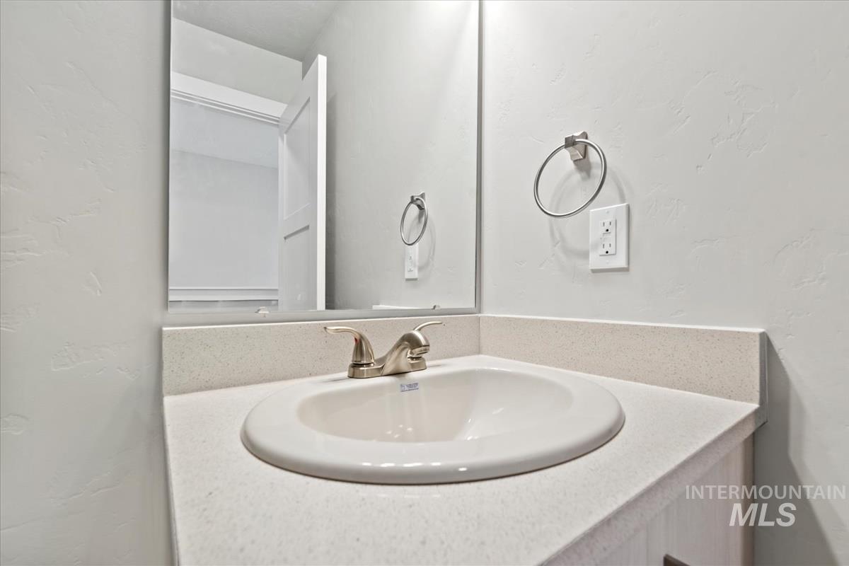 Bathroom with a textured wall and vanity