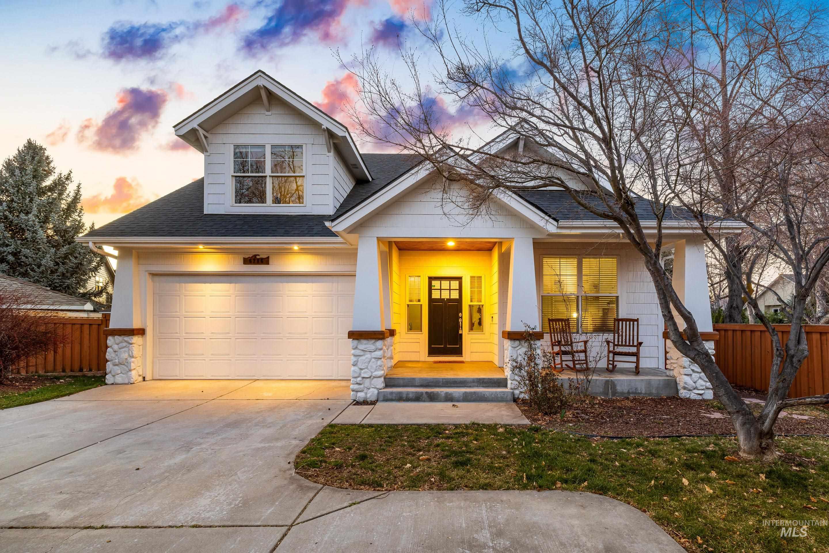 Craftsman-style home with a porch, a shingled roof, driveway, a garage, and stone siding