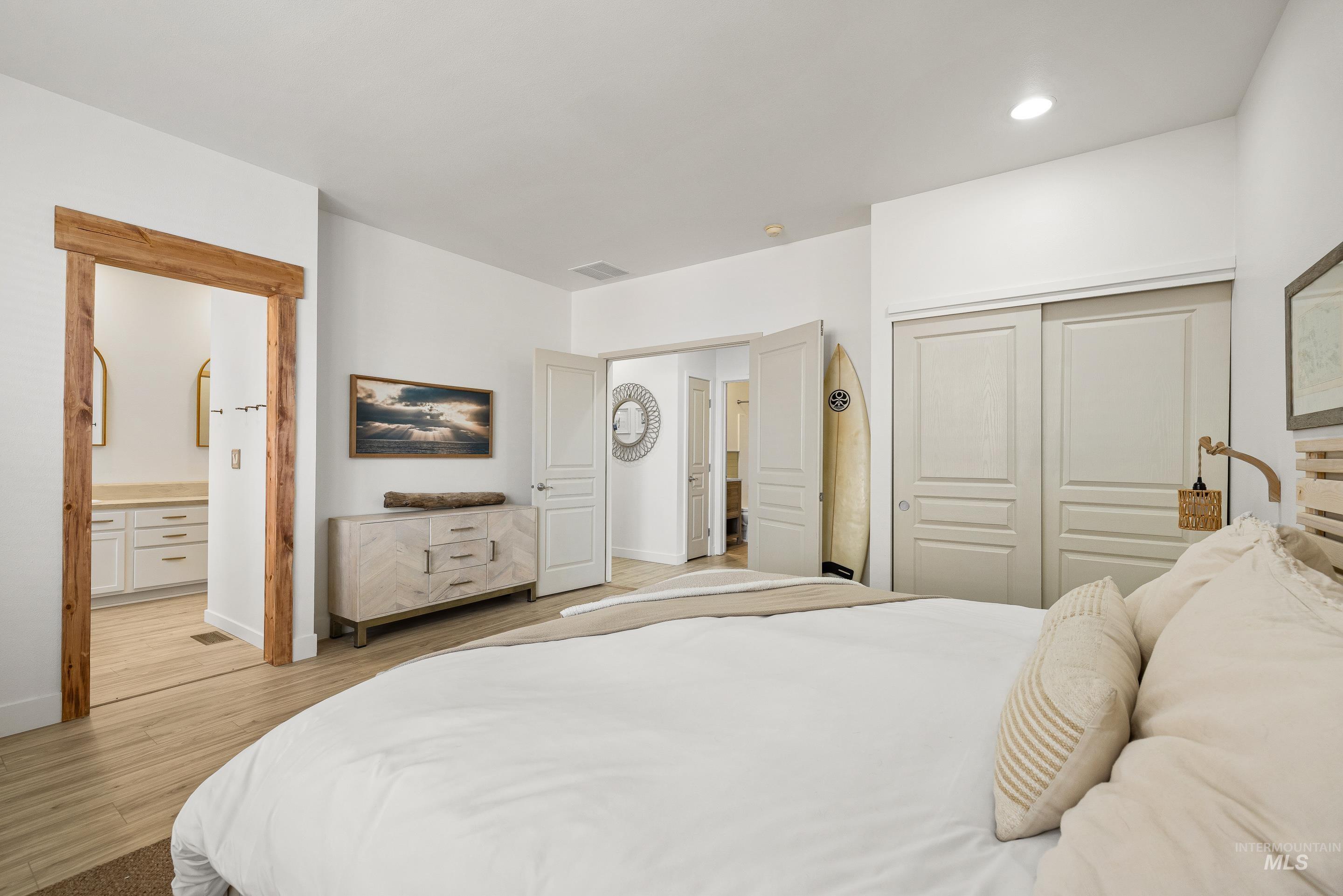 Bedroom featuring a closet, light wood-style flooring, and connected bathroom