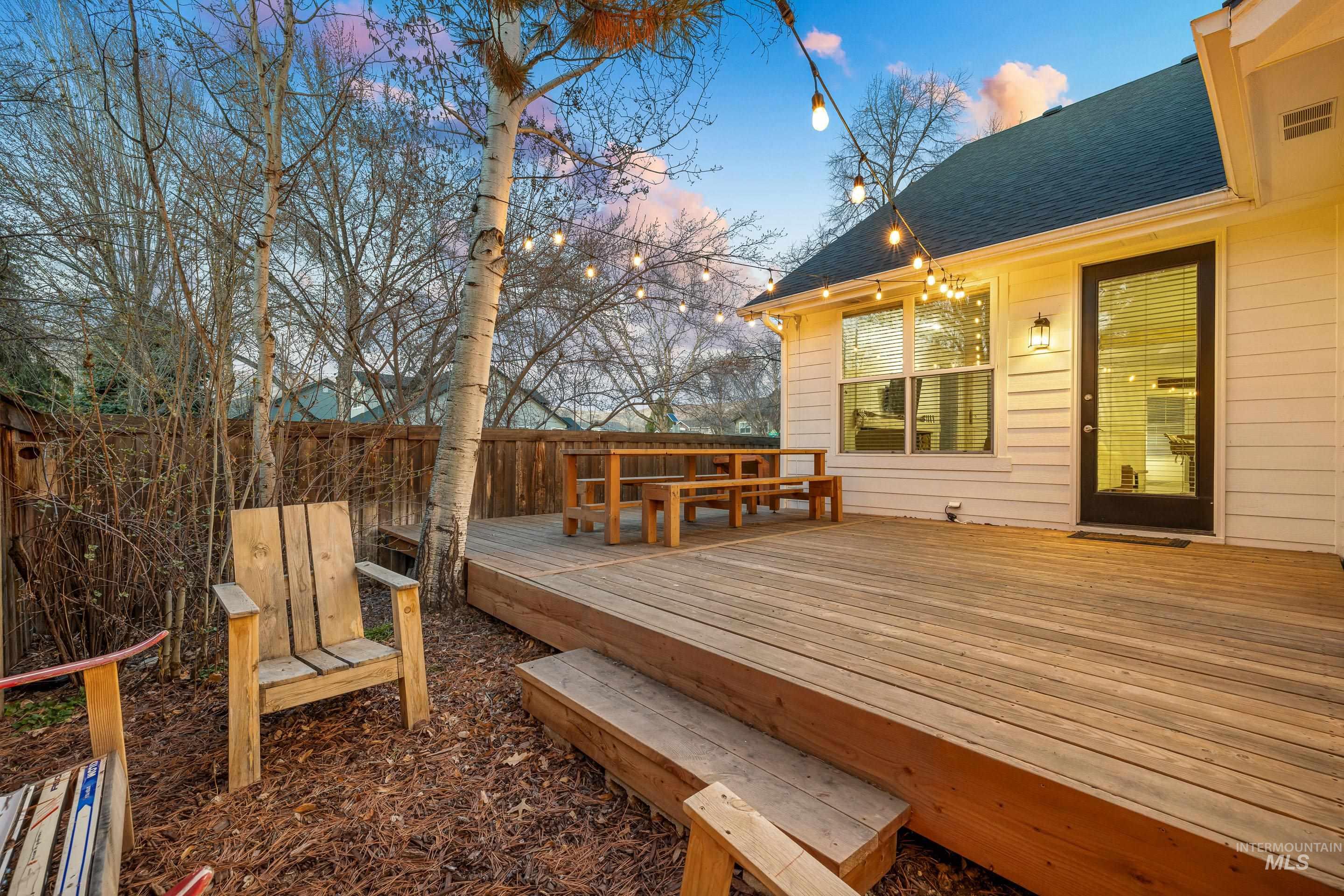 Deck at dusk featuring a fenced backyard