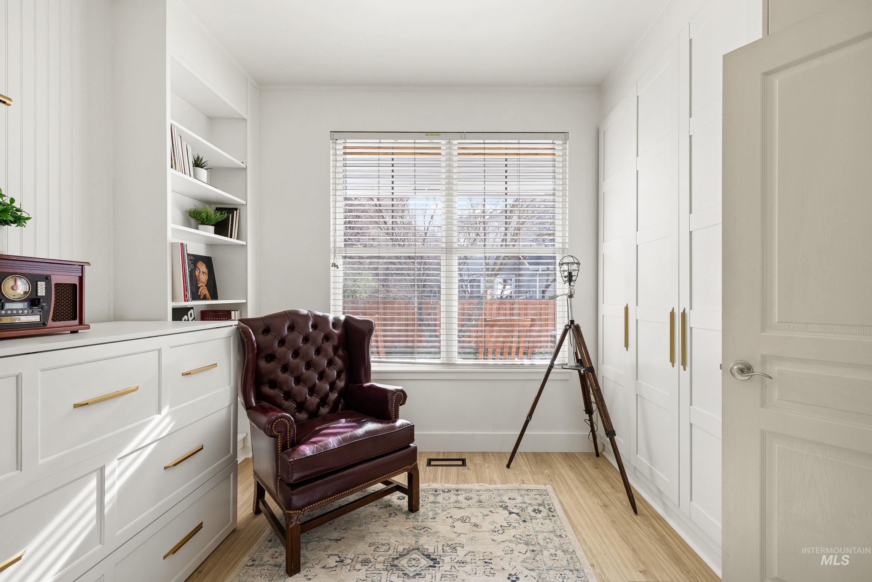 Sitting room with light wood-style flooring and built in features