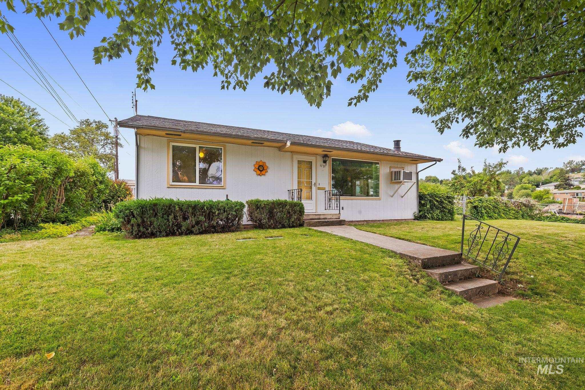 White exterior with a dark roof and light yellow trim
