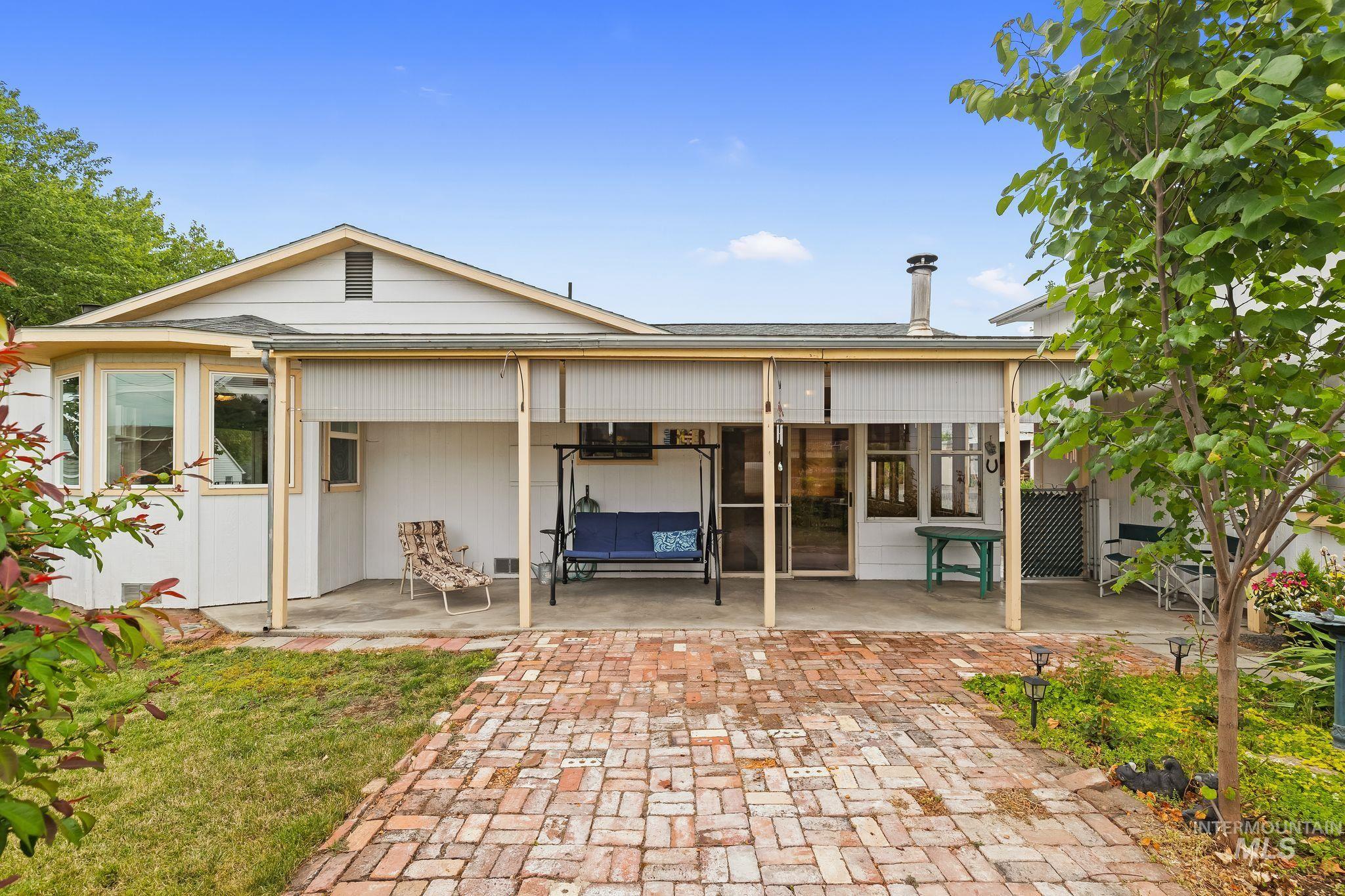 Expansive brick paver patio with a covered section, ideal for outdoor living