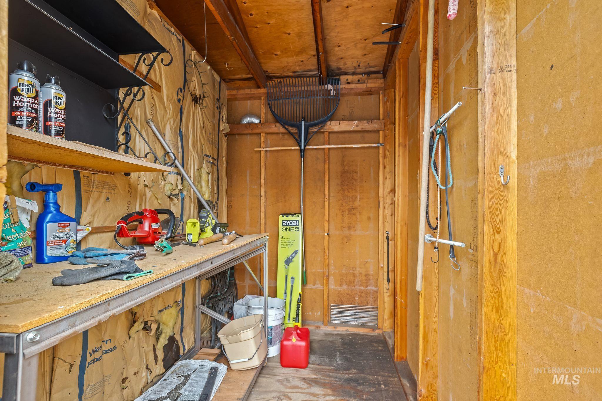 Utility shed interior featuring exposed wood framing and insulation