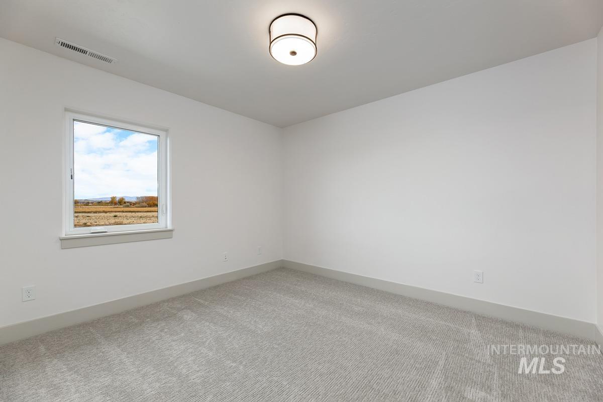 Carpeted empty room featuring baseboards