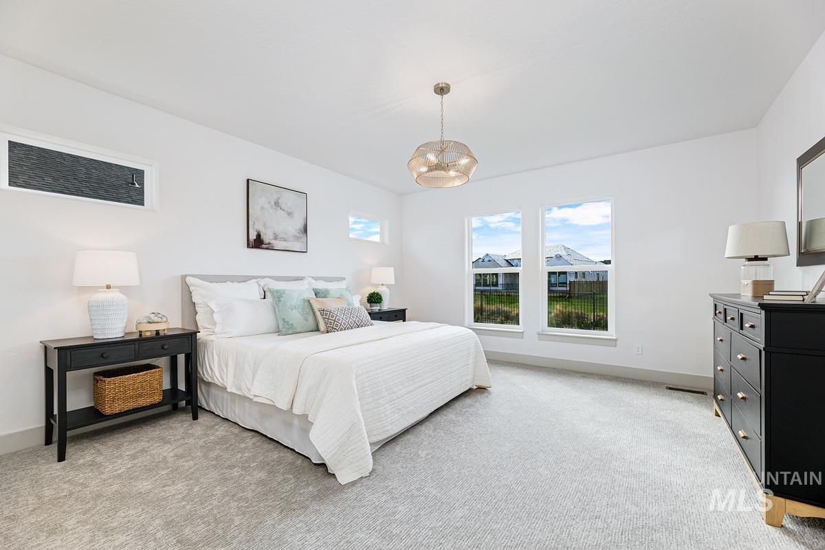Bedroom featuring light carpet and a chandelier