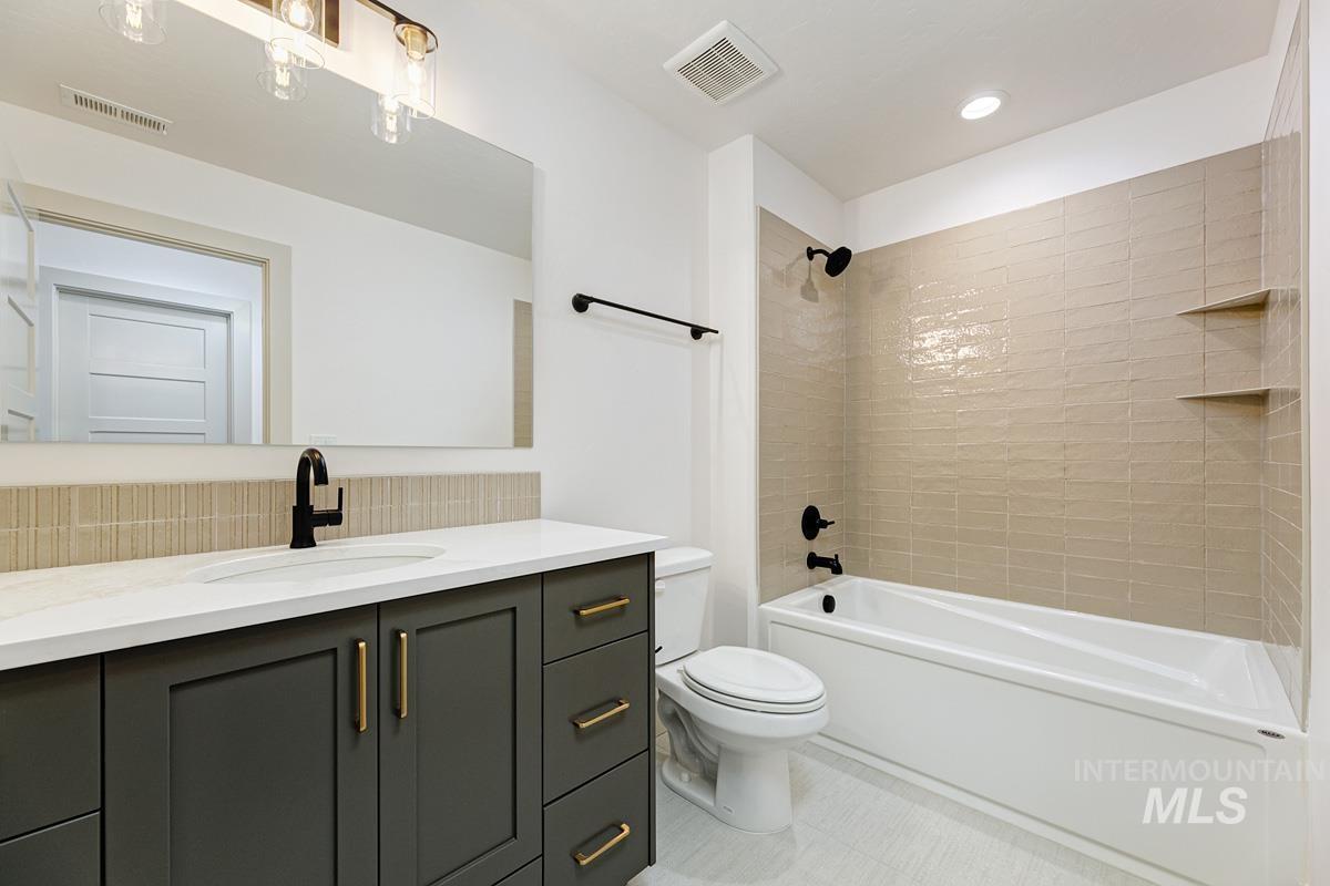 Full bath with vanity, washtub / shower combination, and recessed lighting