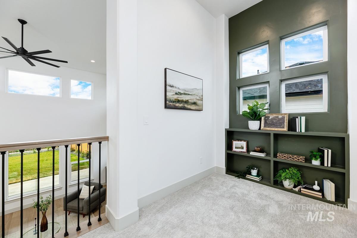 Hallway with carpet floors and a towering ceiling