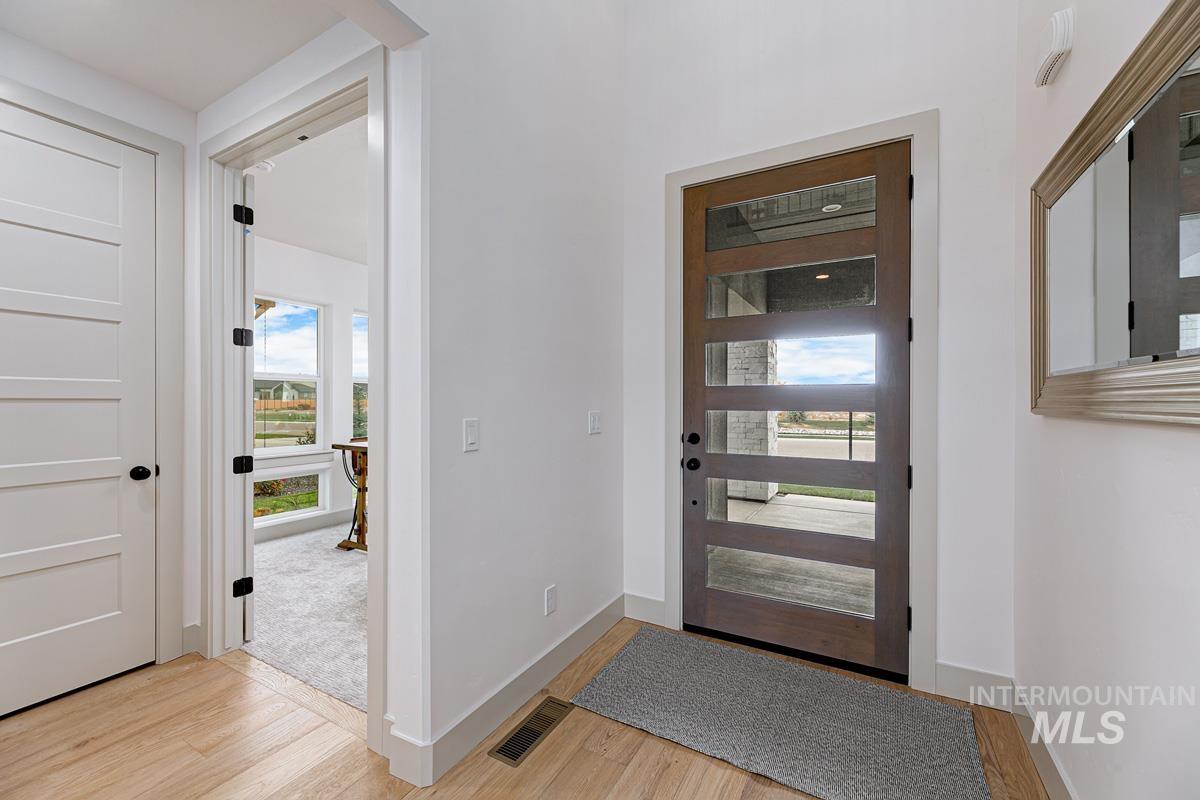 Entryway with light wood finished floors and baseboards