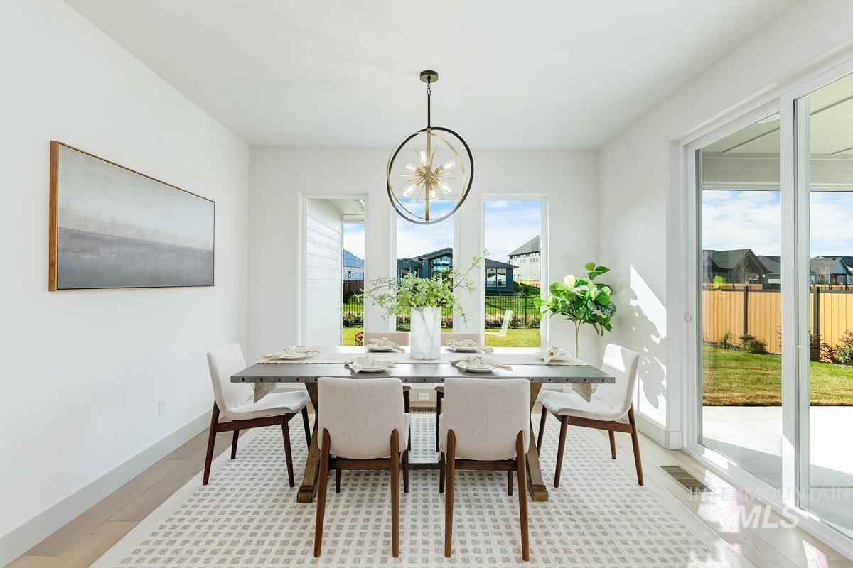 Dining area with plenty of natural light, light wood-style flooring, and a chandelier