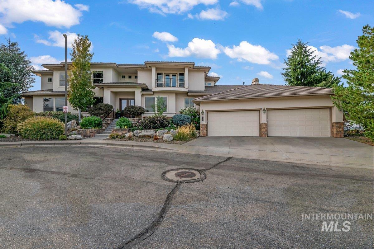 Prairie-style home with stucco siding, concrete driveway, stone siding, and a garage