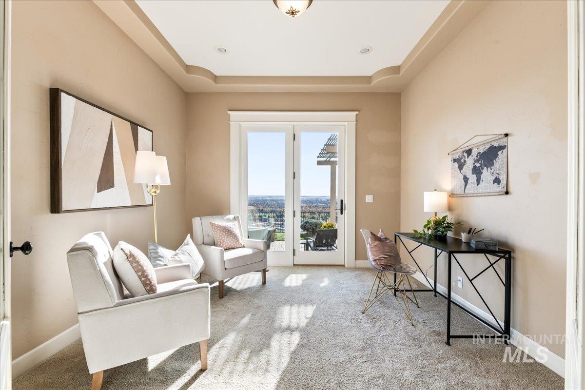 Sitting room featuring carpet flooring and a tray ceiling