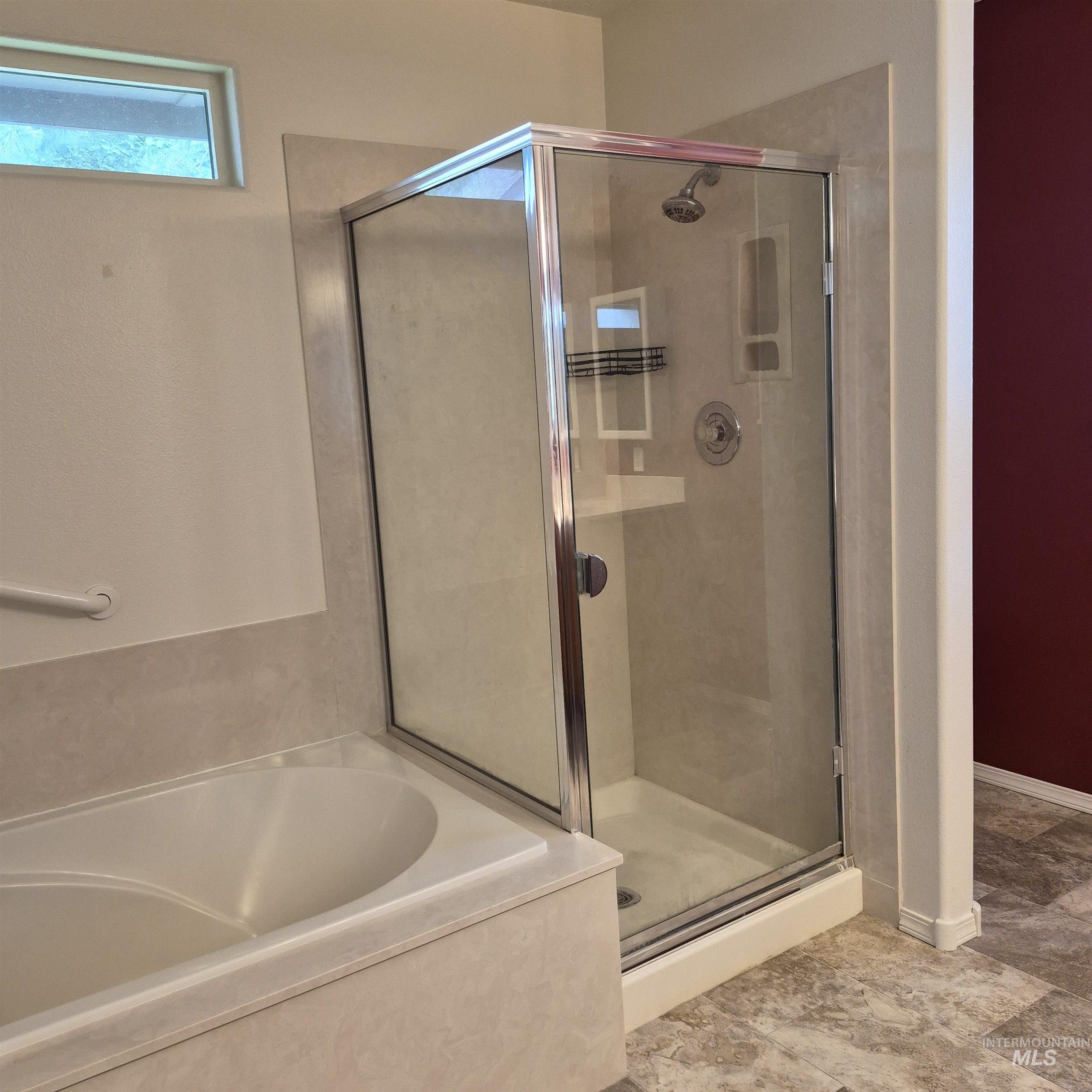 Glass-enclosed shower and soaker tub.