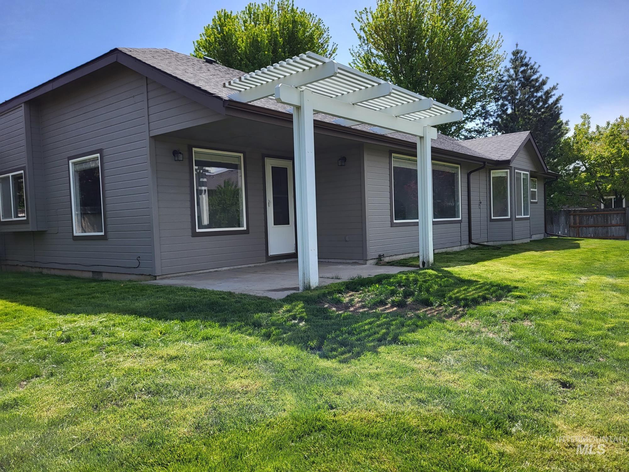 Rear exterior featuring a covered concrete patio augmented with a white pergola