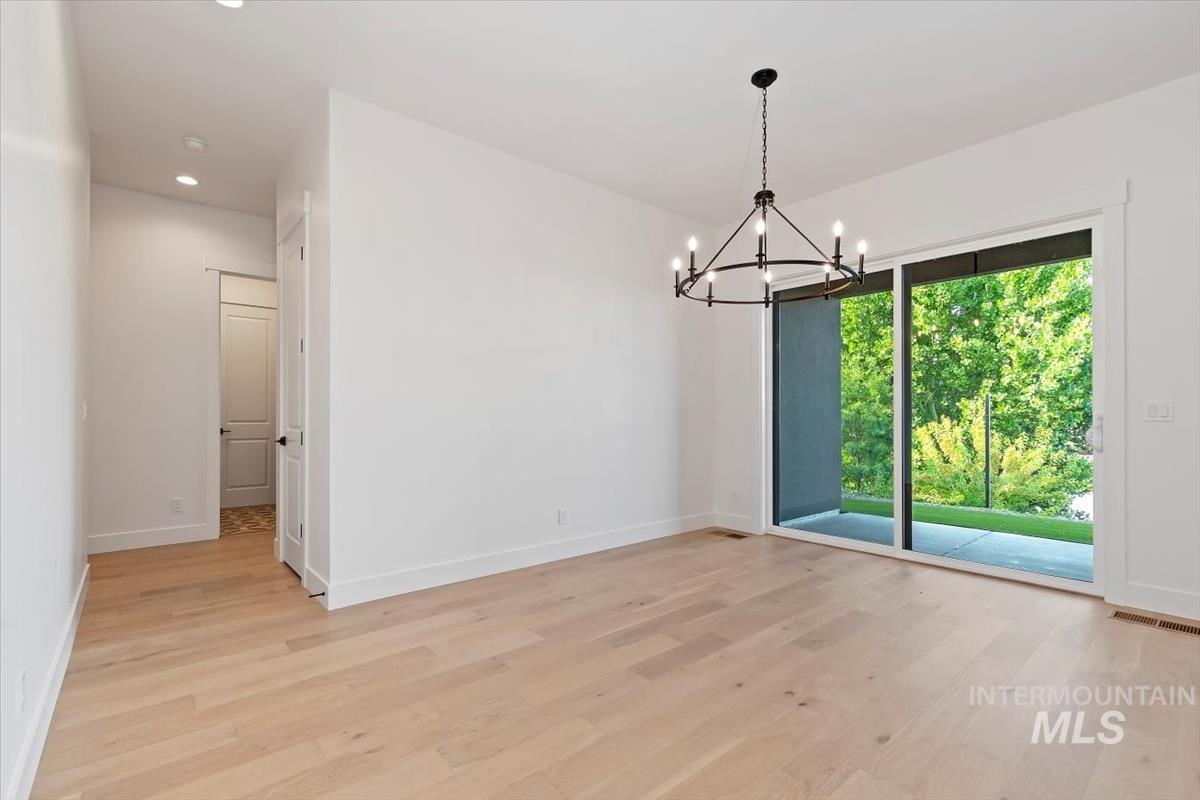 Unfurnished room with a chandelier, light wood-style flooring, and recessed lighting