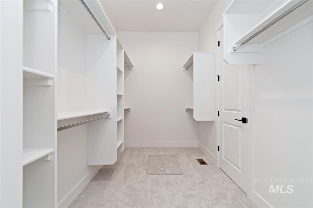 Walk in closet featuring light carpet